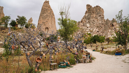 Uchisar Castle entrance path with view of the extensively hollowed out rock pillars, spires and...