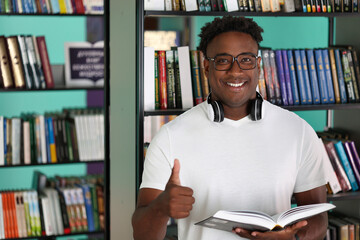 Black male tourist exploring local bookstores while traveling. Stylish young african american man...