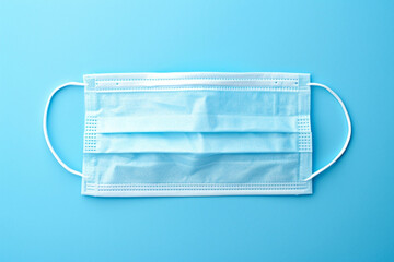 Medical face mask on blue background. Coronavirus concept.