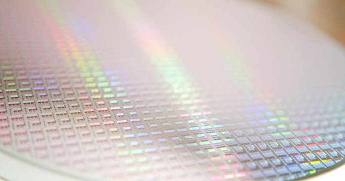 A close-up view of a silicon wafer's microprocessor circuit layout. The semiconductors or central processing unit CPU microchips are fabricated from a silicon wafer with patterned layers of materials.