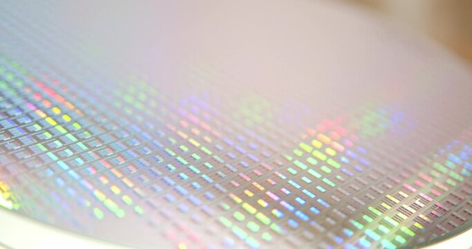A close-up view of a silicon wafer's microprocessor circuit layout. The semiconductors or central processing unit CPU microchips are fabricated from a silicon wafer with patterned layers of materials.