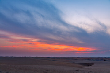 Fototapeta na wymiar Beautiful dramatic clouds sunset sunrise over the desert sand dune of Abu Dhabi, UAE
