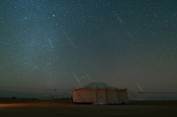 night Star trailing motion with Gemini Meteors shooting in safari desert camping