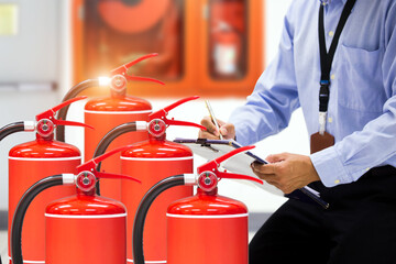 Fire extinguisher has hand engineer checking pressure gauges with exit door to prepare fire...
