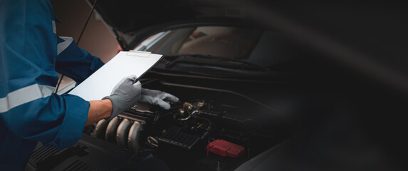 Hand auto mechanic checking inspection list after fix or repairing change spare part engine problem...