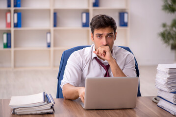 Young male employee and too much work in the office