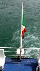 The rear flag of a ferry in Italy towards the Mediterranean islands.