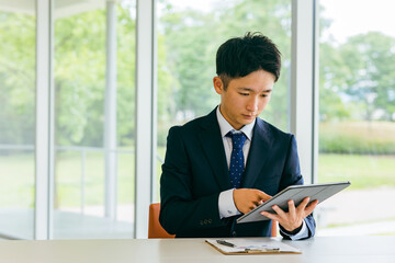 Fototapeta premium タブレットを使い検索するビジネスマン（分析・電子サイン・ペーパーレス） 