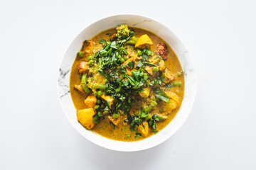 plant-based potato and vegetable green curry with fresh herbs