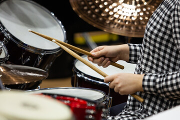 Hands of a girl playing a drum set