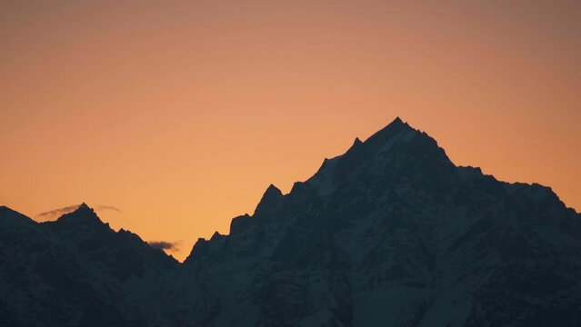 Silhouette shot of snow covered Kinnaur Kailash mountain during the sunrise in winter as seen from Kalpa in Kinnaur, Himachal Pradesh, India. View of Holy Kinnaur Kailash mountain range in morning.