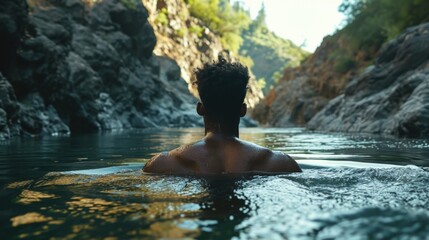African American man swimming in a mountain river 