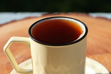 Cup Of Tea Closeup Over Nature Green Background. Pouring green tea in cup. Glass tea pot. Hot healthy drink