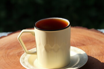 Cup Of Tea Closeup Over Nature Green Background. Pouring green tea in cup. Glass tea pot. Hot healthy drink