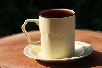 Cup Of Tea Closeup Over Nature Green Background. Pouring green tea in cup. Glass tea pot. Hot healthy drink