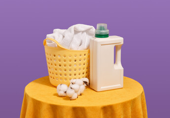 A yellow basket of dirty clothes and laundry detergent. Laundry room.