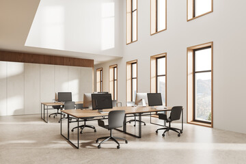 Cozy modern coworking interior with pc computers and panoramic window