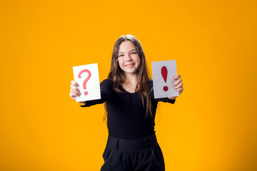 A portrain of kid girl holding cards with question mark and exclamation point. Children, idea and...