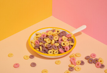 Brightly colored breakfast cereal. Plate and spoon.