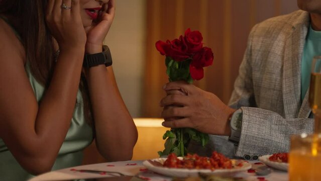 headless shot, young man proposing to girlfriend during valentines day candlelight dinner - concept of date night, relationship bonding and affection