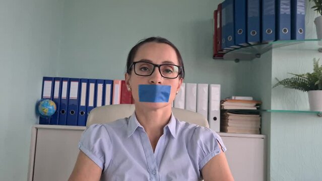 Protesting woman covered mouth with tape and kept hand and feet silent. Silence and violence and harassment against women