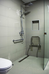 Accessible shower with a chair, promoting inclusion in hotels. Comfort and accessibility for all...