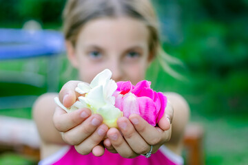 Girl with Flowers. Cute Little Girl Holding a Pink and White Rose Petals in the Park