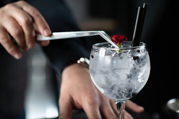 Bartender Enhances Gin Tonic Cocktail with edible flowers