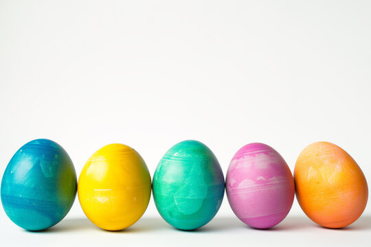 Colorful easter eggs in a row and in front of a white background and space for text. Minimalist Easter composition. Greeting trendy color concept with copyspace. design template, free copy space