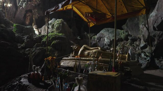 Sacred cave of Tham Phu Kham Vang Vieng, Laos - a stalactite and a stalagmite in the karst mountain with buddha temple inside