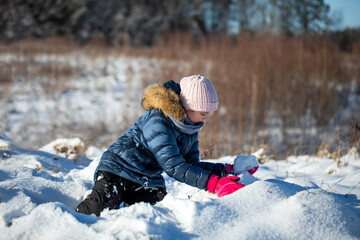 dziewczynka bawi się na śniegu zimą w ferie zimowe - obrazy, fototapety, plakaty