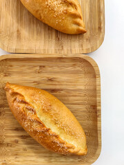 Delicious sweet ruddy small pie on square wooden bamboo plate. Two serving of fresh pastries, sprinkled with sugar. Top view.