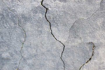 Obraz premium The wall of an old building with many winding, deep cracks. Copy space. Selective focus.