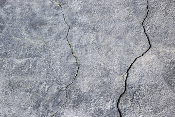 Obraz premium The wall of an old building with many winding, deep cracks. Copy space. Selective focus.