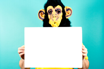 Man in Monkey Mask Holding Blank Sign