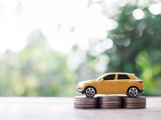 Toy cars on stack of coins. The concept of saving money and manage to success transport business