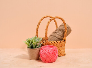Fototapeta na wymiar Decorative wicker basket with jute twine. Garden ribbon and plant.