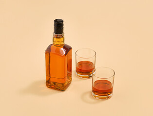 A bottle of brown alcoholic beverage and two glasses. Alcohol vacation. Cheerful party.