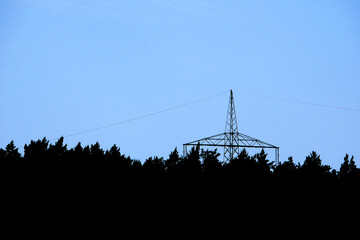 electricity power line and tower above a forest