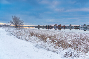 Blick über die Warnow auf die Hansestadt Rostock im Winter - 713923486