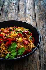 Asian style stir fried vegetables and noodles on wooden table
