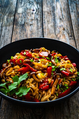 Asian style stir fried vegetables and noodles on wooden table
