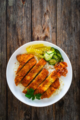 Torikatsu - crispy Japanese chicken cutlet with white rice and marinated vegetables on wooden table
