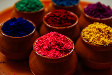 Various Holi paints in pots on a tray. Colorful background for the national Indian holiday Happy Holi