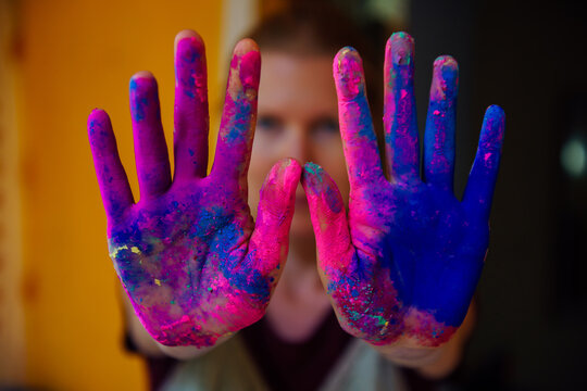 Women's palms covered with bright dry Holi paint. Hands covered in dry paint
