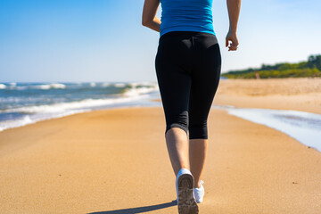 Mid adult beautiful woman running on sunny beach 