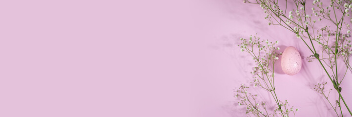 Spring flowers and colorful Easter eggs on a pink background, celebrating the holiday, banner