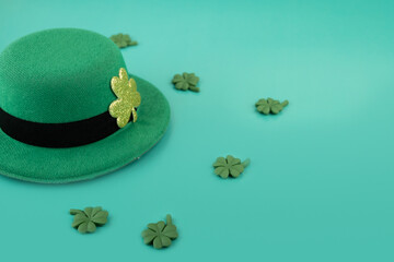 green irish leprechaun hat with shamrocks on green background, saint patrick day, copy space