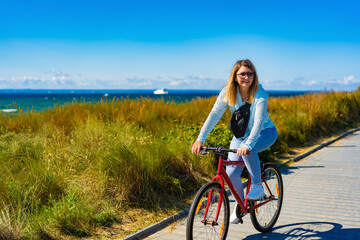Mid adult woman riding bicycle at seaside

