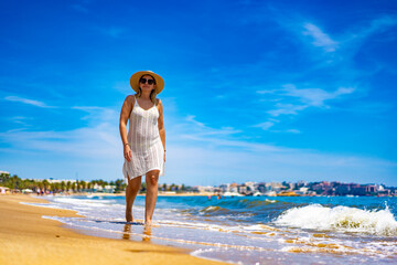 Beach holidays - woman walking on beach on Costa Dorada Spain
